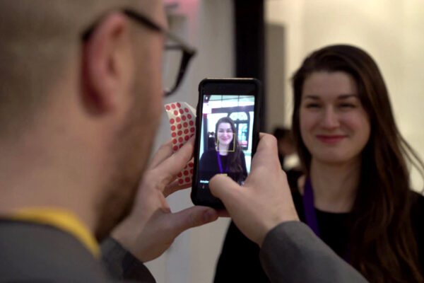 Men taking a photography with phone to a smiling girl